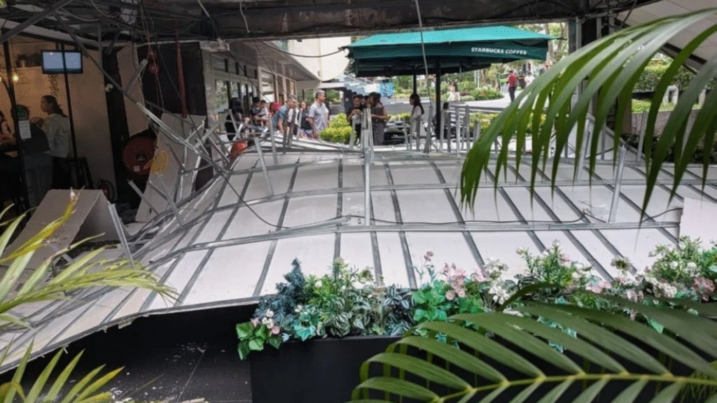 Wide view of the entire fallen ceiling structure at Liat Towers with onlookers and emergency tape.