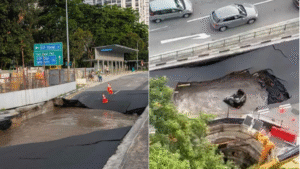A large sinkhole forming along Tanjong Katong Road in Singapore with water pooling, road cones, and construction workers nearby.