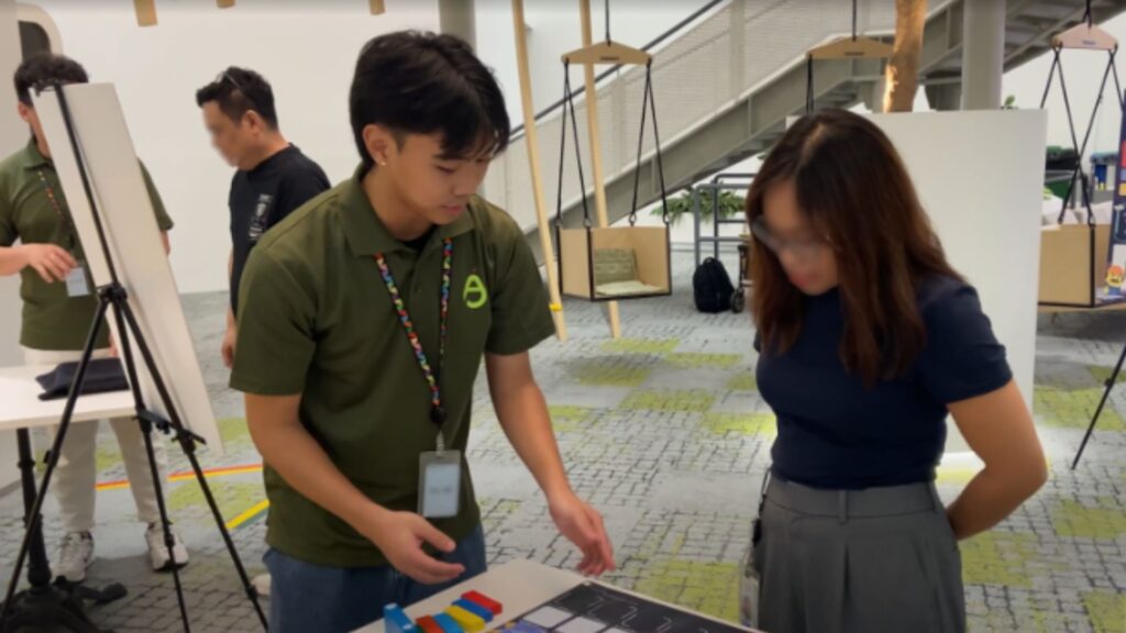 Safety specialist guiding worker through an interactive safety game designed to teach hazard awareness and prevention