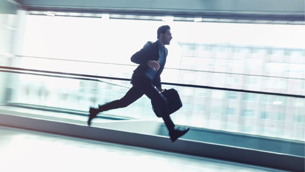 Businessman in motion running quickly through a corridor
