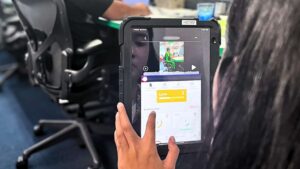 Ergonomist conducting an ergonomic risk assessment using a digital tool to evaluate an office workstation in Singapore