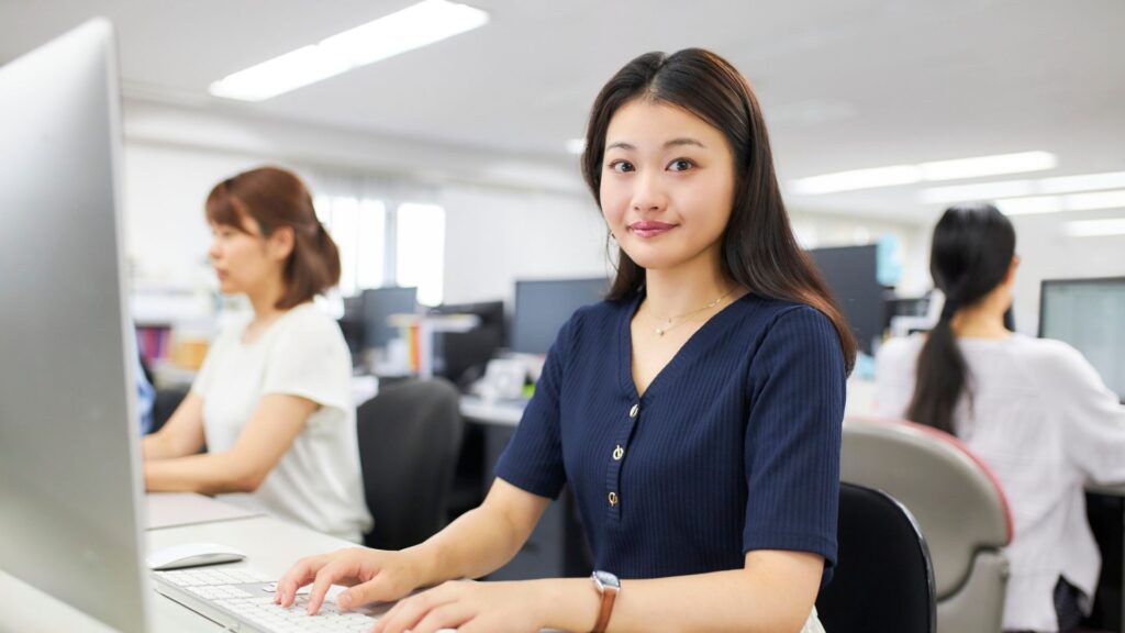 Office employee working comfortably after workstation ergonomics assessment and posture adjustment