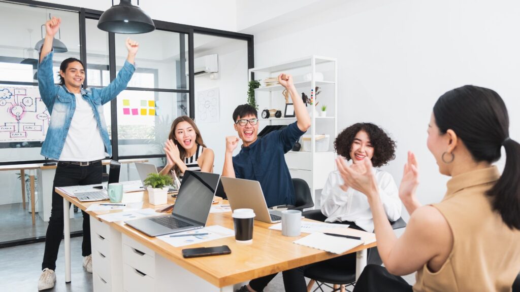 Office team celebrating improved comfort and wellbeing after ergonomic improvements at work