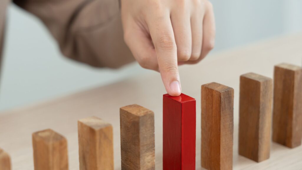 Hand highlighting a high-risk hazard during a WHS risk assessment process in Singapore