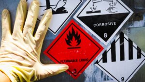 Common workplace safety hazards in Singapore including chemical and physical hazard warning signs in an industrial environment