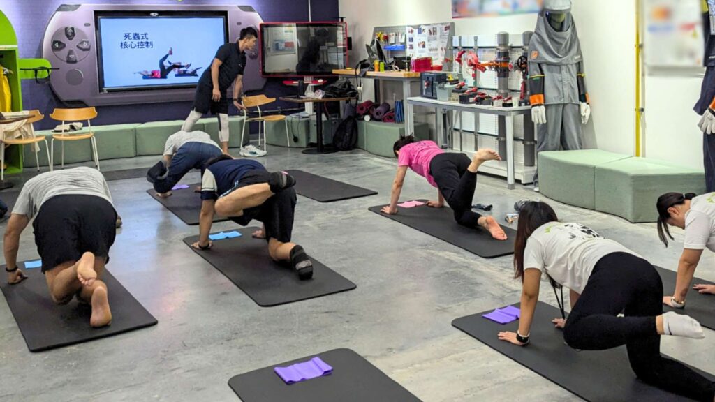 Employees participating in guided movement exercises to reduce ergonomic risk and support musculoskeletal health