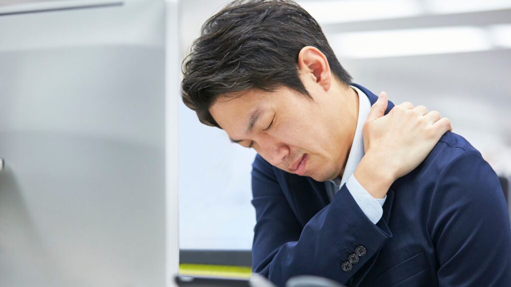 Workplace Ergonomics Singapore – office worker experiencing neck and shoulder pain from poor workstation posture