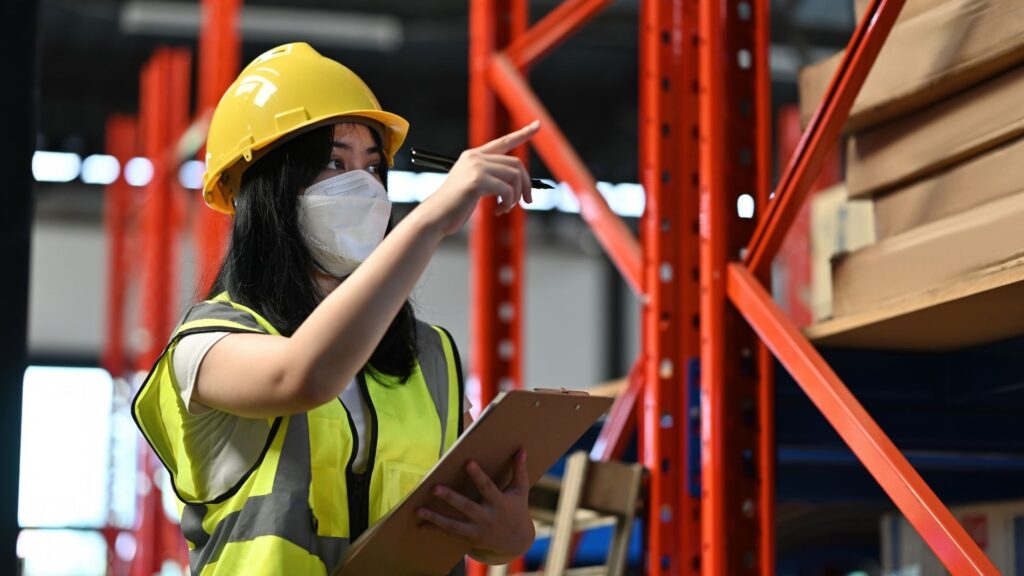 Safety officer conducting workplace safety inspection in a warehouse environment in Singapore to identify hazards and ensure WSH compliance.