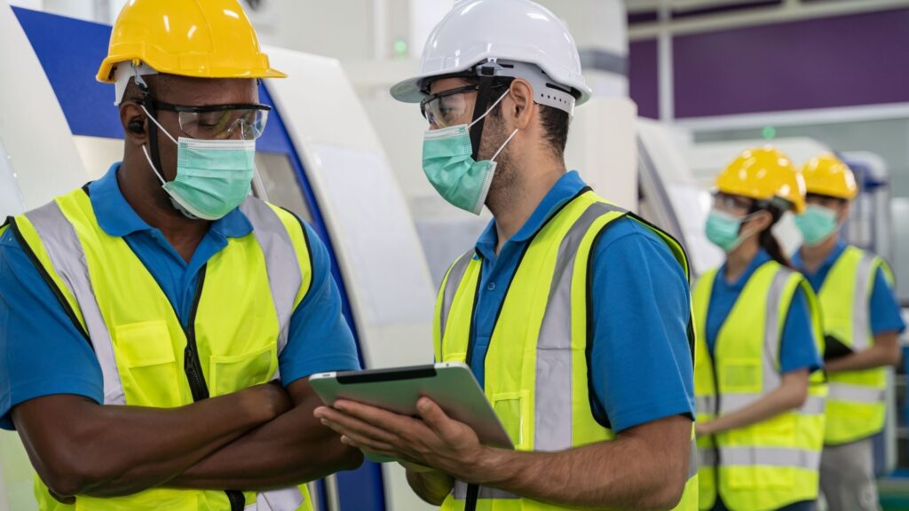 Industrial workers reviewing safety procedures and risk management practices as part of workplace safety and health implementation in Singapore.
