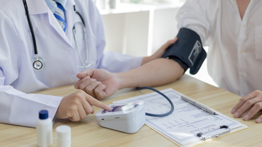 Doctor conducting blood pressure test during on-site health screening for employees in Singapore workplace