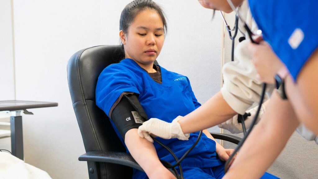 Employee undergoing blood pressure and health checks during on-site health screening in Singapore