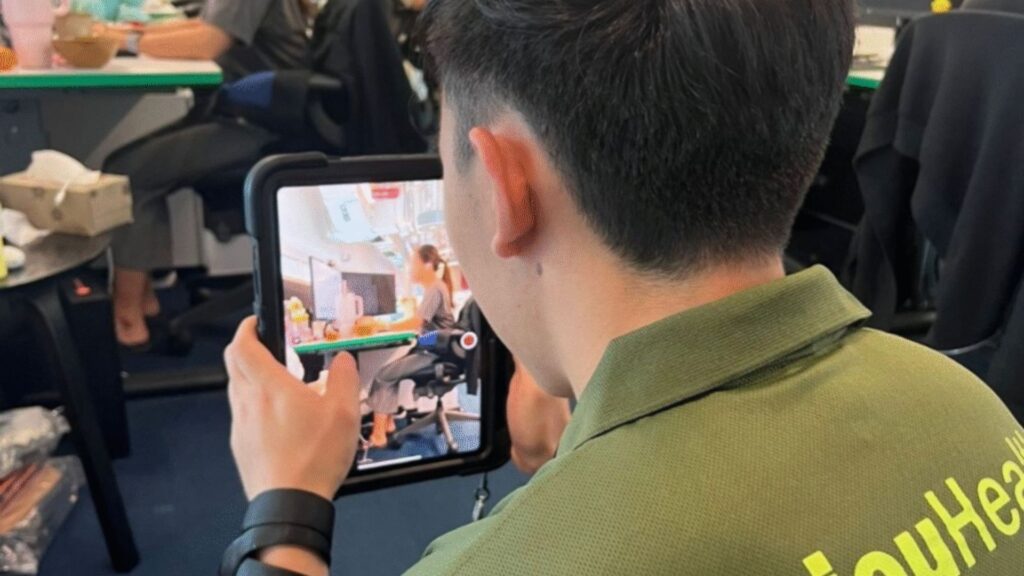 Person holding a tablet and recording video footage in an office environment