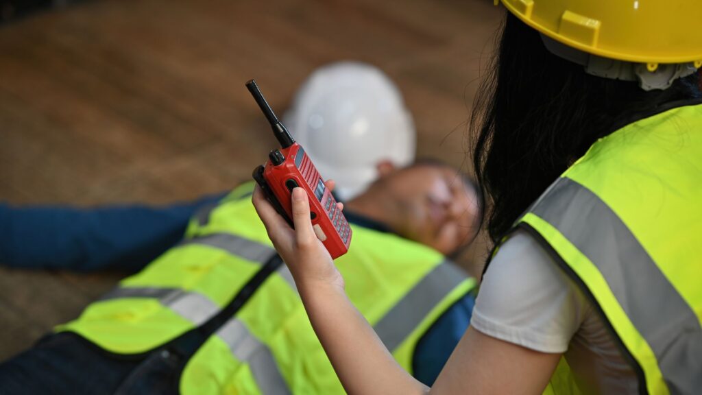 Safety officer responding to a workplace incident involving an injured worker, illustrating the importance of identifying workplace hazards in Singapore