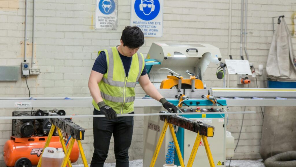 Factory worker operating industrial machinery, representing potential workplace hazards in Singapore such as unsafe equipment and operational risks