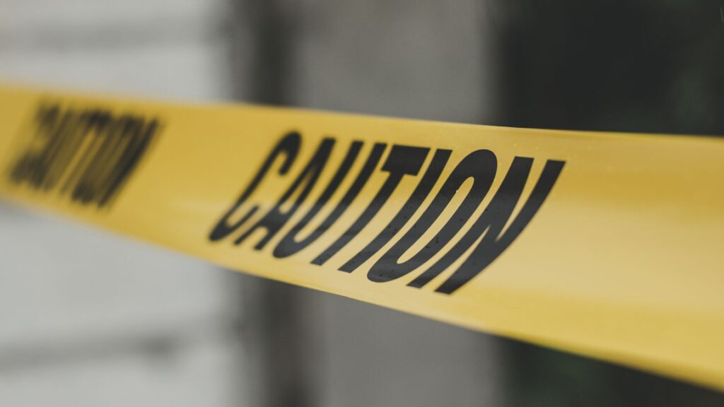 Caution tape marking a hazardous area in the workplace, demonstrating hazard identification and risk prevention measures