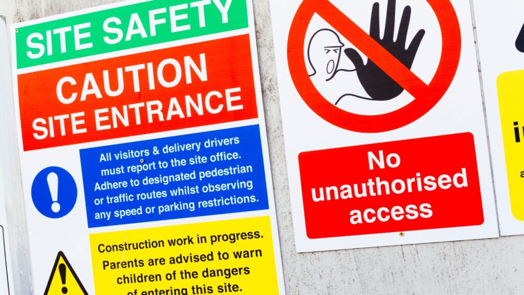 Workplace safety signs showing restricted access and hazard warnings supporting safety policies in an occupational health and safety program