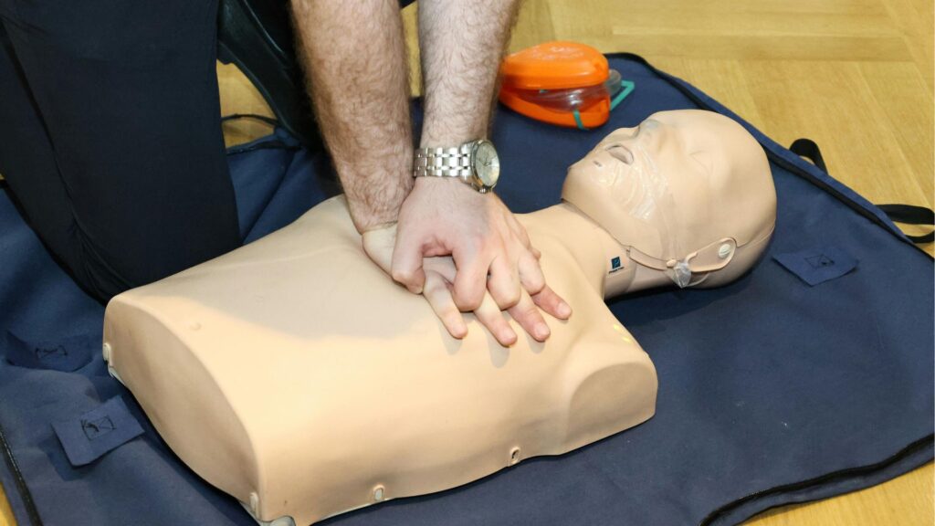 Employee performing CPR training during workplace safety training under an occupational health and safety program