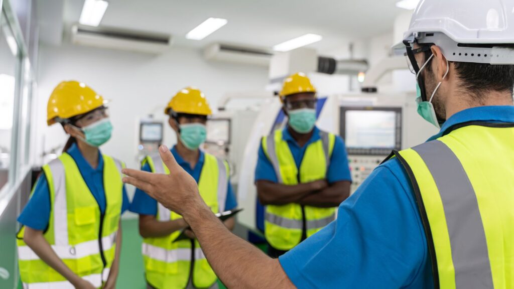 supervisor conducting workplace safety briefing with workers wearing ppe singapore safety responsibilities training session