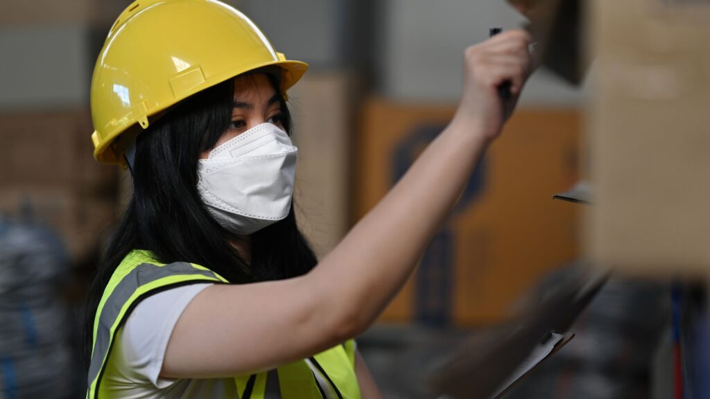 Warehouse employee conducting inventory safety check to prevent workplace accidents and improve occupational health compliance