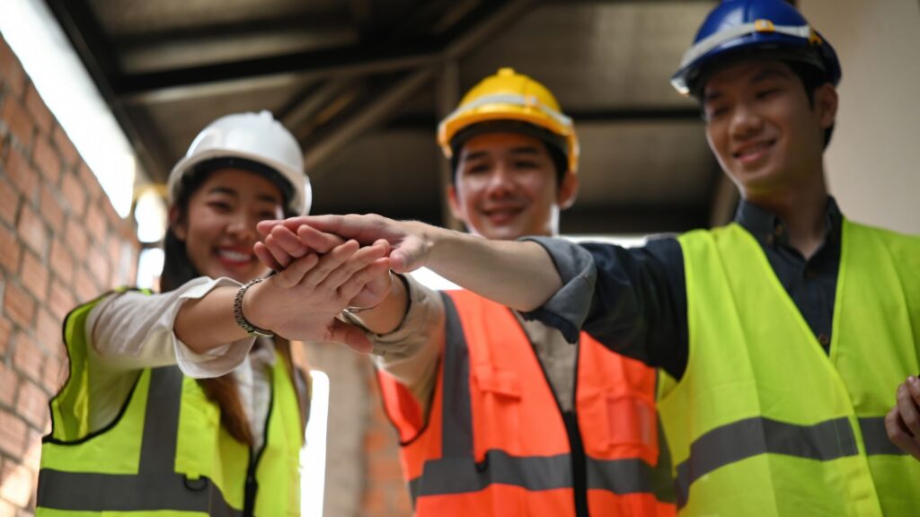 Warehouse workers showing teamwork commitment to workplace safety and injury prevention culture in Singapore logistics environment