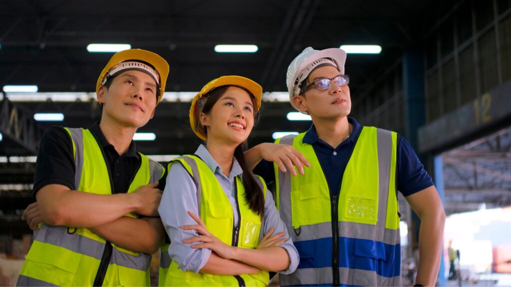 bizSAFE certified workers in safety vests and hard hats at industrial workplace Singapore