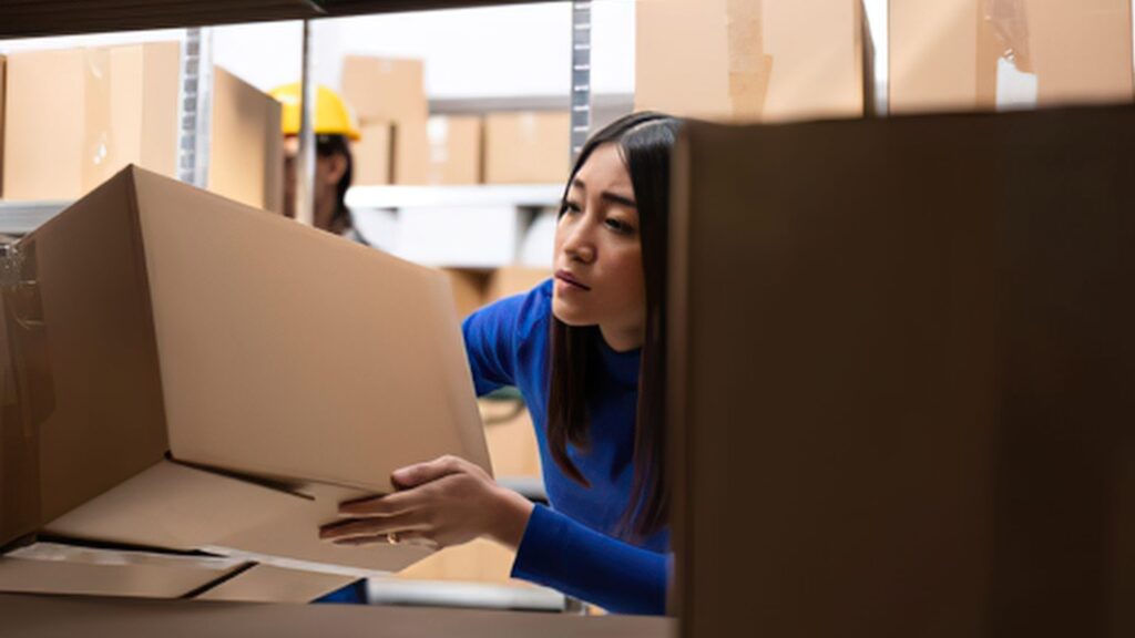 worker performing manual handling task with ergonomic injury risk Singapore logistics warehouse