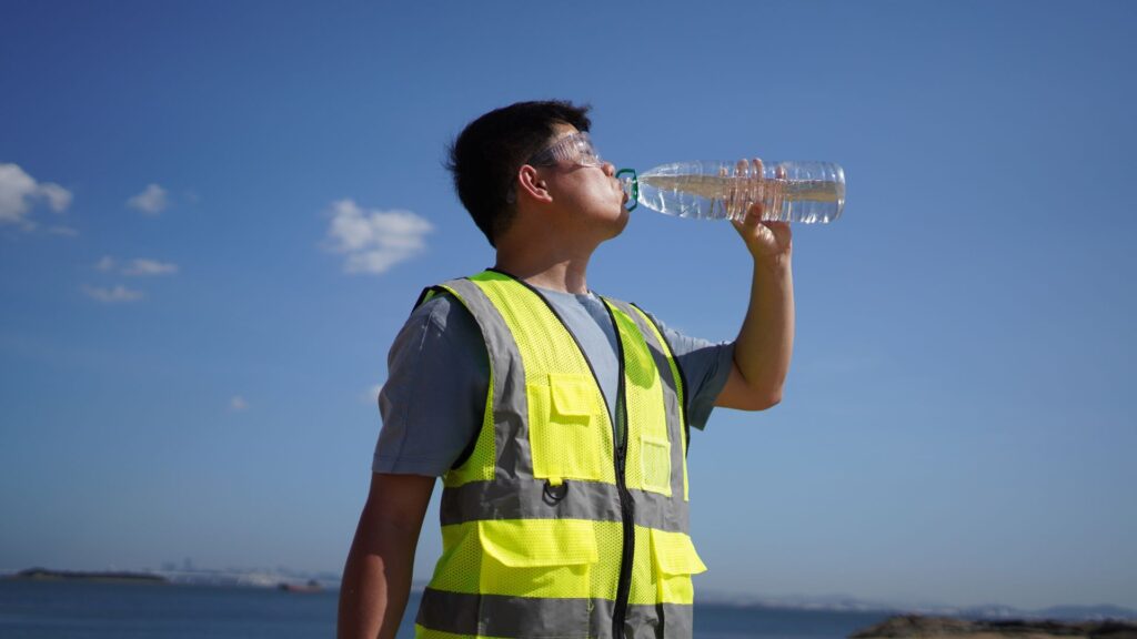 outdoor worker hydrating to prevent heat stress Singapore workplace heat management